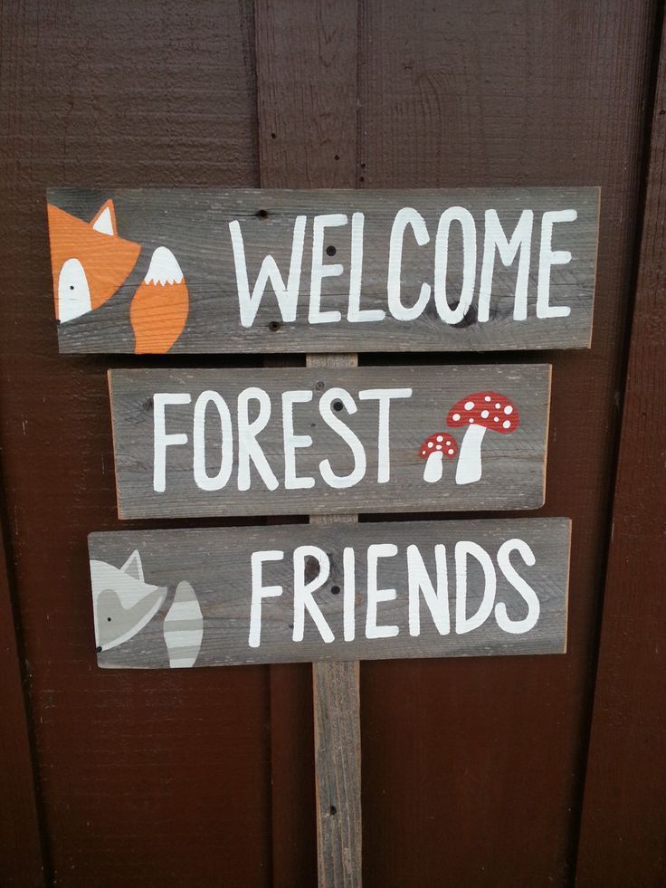 a wooden sign that says welcome forest friends and a red fox with a mushroom on it