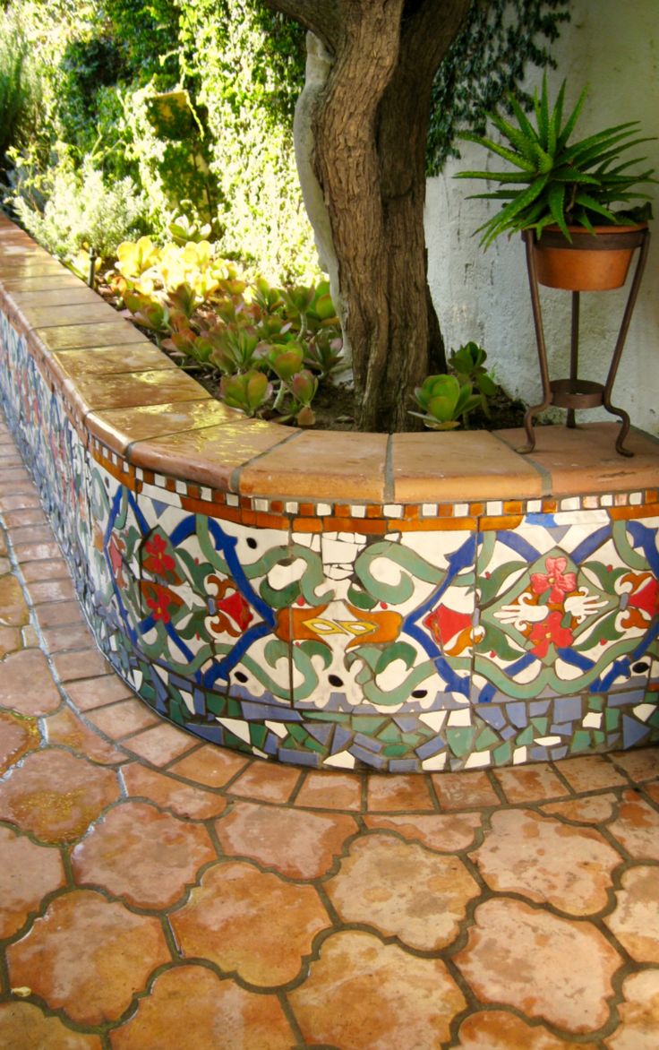 an outdoor area with tiled walls and potted plants