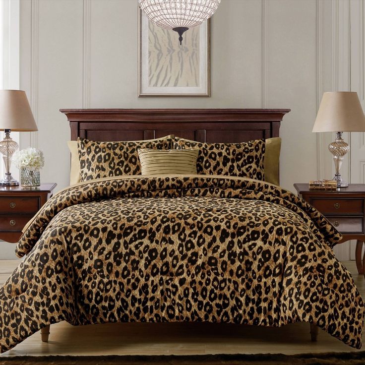 a leopard print comforter set on a bed in a room with two nightstands