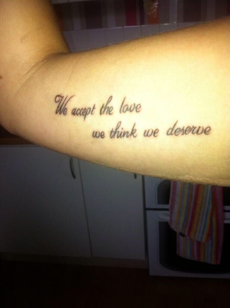 a person with a tattoo on their arm that says, we accept the love we think we