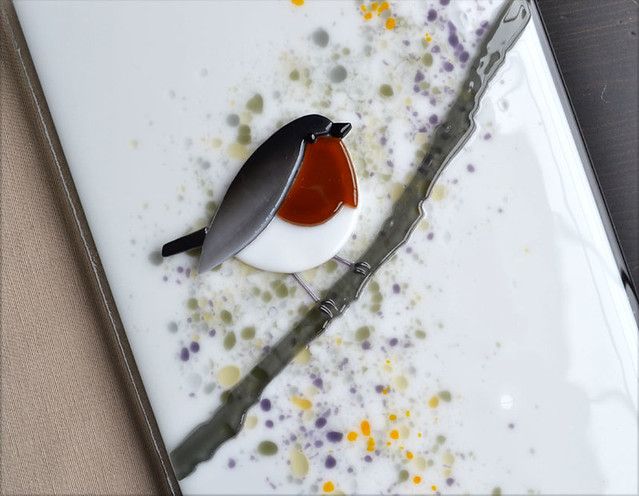 a small bird sitting on top of a white plate