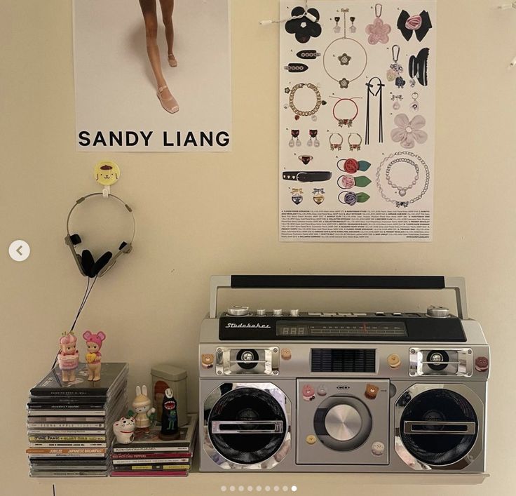 an old radio sits on a shelf in front of a wall with pictures and jewelry