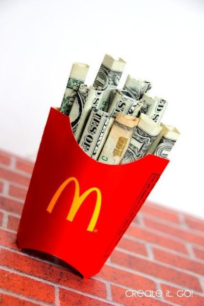 a mcdonald's bag full of money sitting on top of a red brick wall