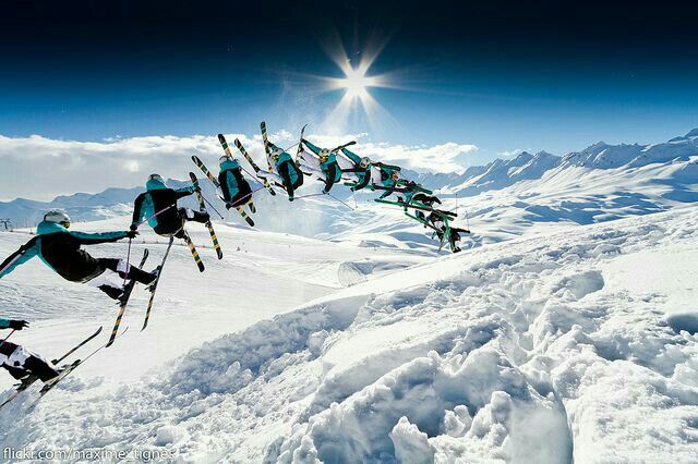 a group of skiers are doing tricks in the air on a snowy mountain slope