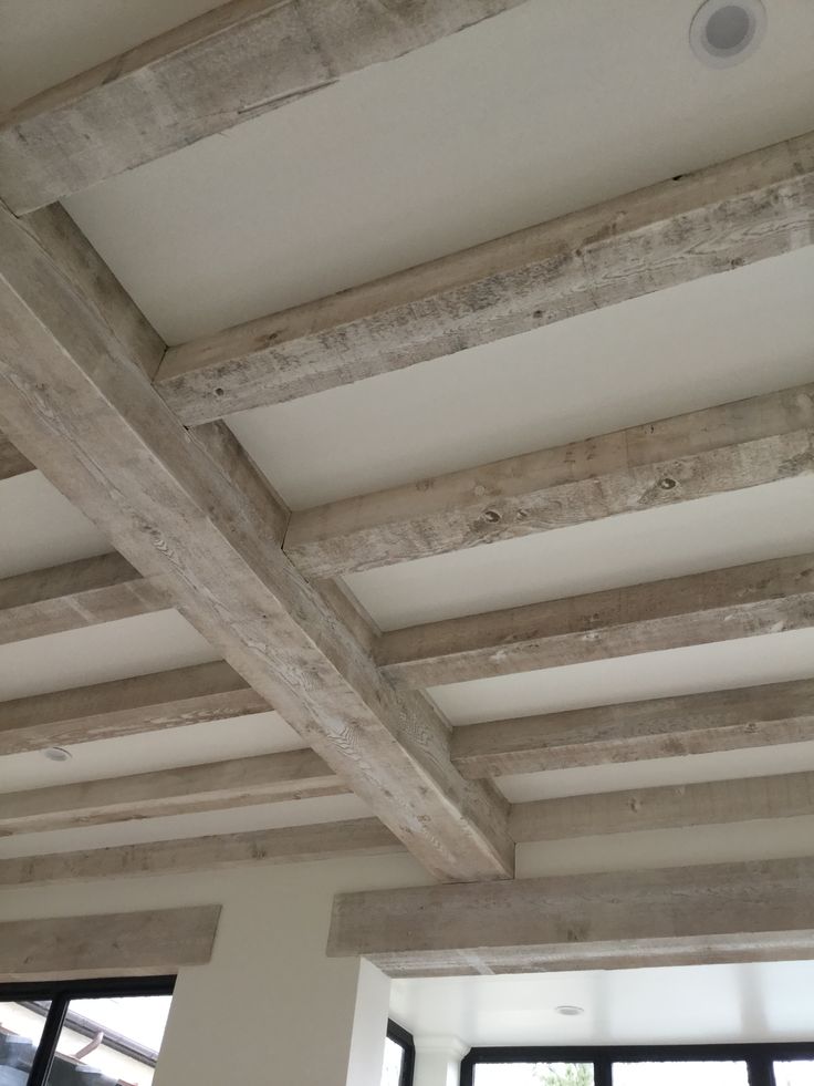 an unfinished ceiling with wooden beams and windows