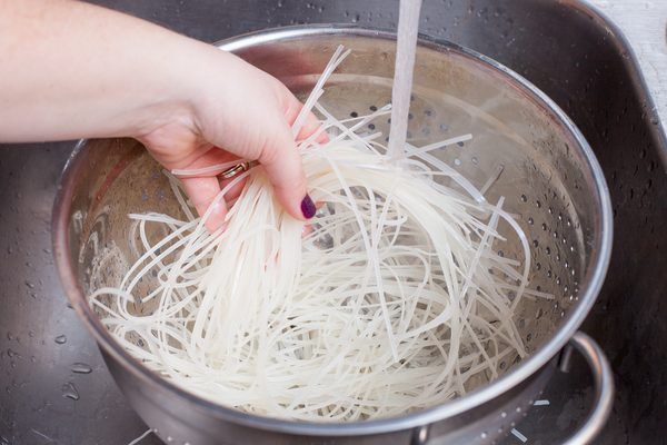 someone is stirring noodles in a pot on the stove