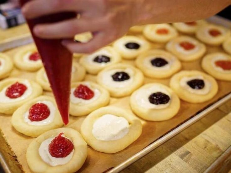 a person is spreading jam on some cookies