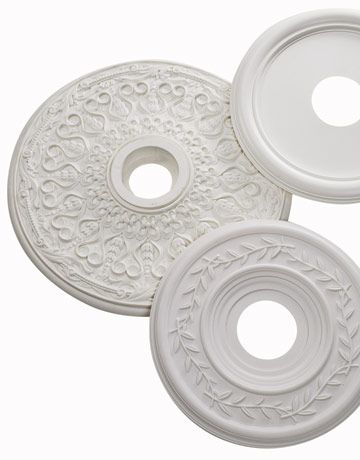 two white plates with decorative designs on the top one has a circular hole in the middle