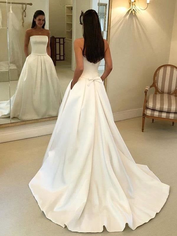 a woman standing in front of a mirror wearing a wedding dress