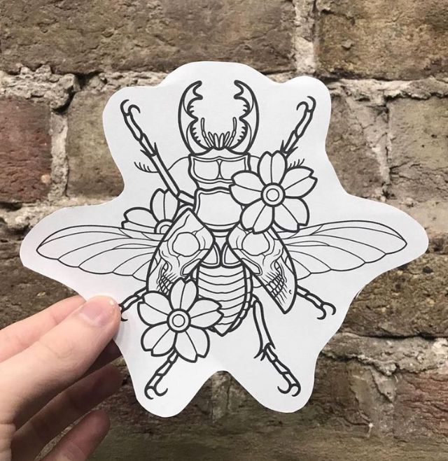 a hand holding up a sticker with a drawing of a bee and flowers on it