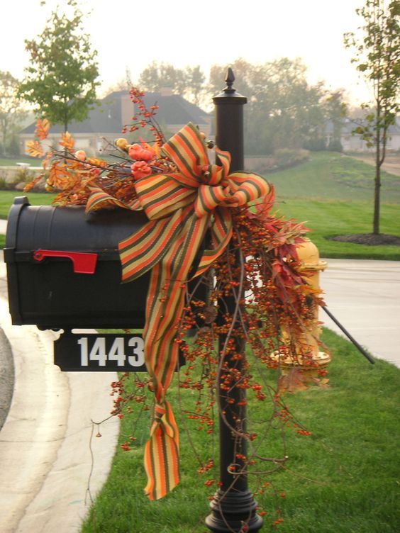 a mailbox tied to a post with an orange bow