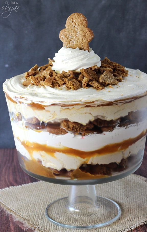 a layered dessert in a glass dish with a cookie on top