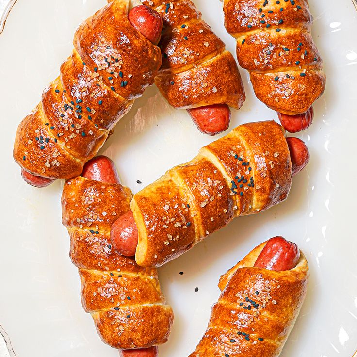 hot dogs wrapped in bread on a plate