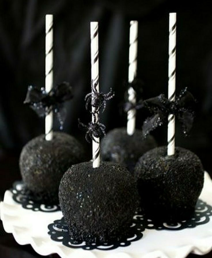 black cake pops are on a white plate