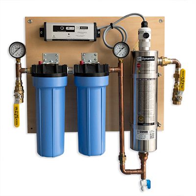 two water filtrators are attached to a wall with pipes and gauges