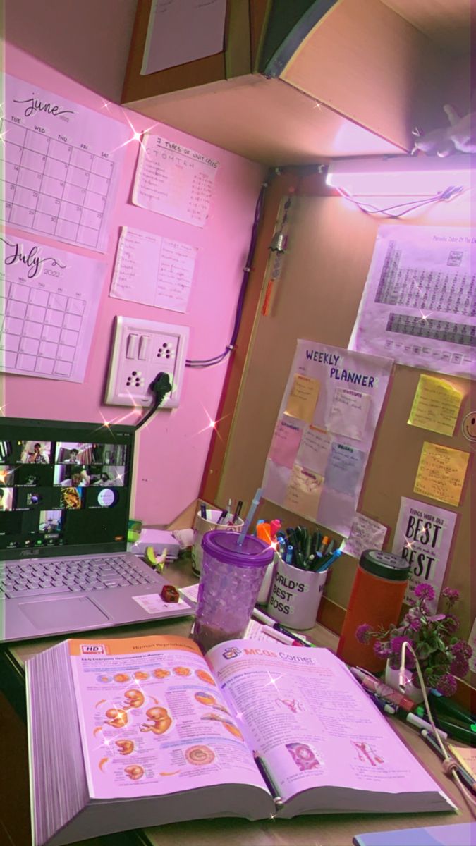 an open book sitting on top of a desk next to a laptop computer and monitor