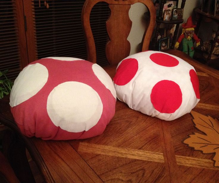 two red and white polka dot pillows sitting on top of a wooden table