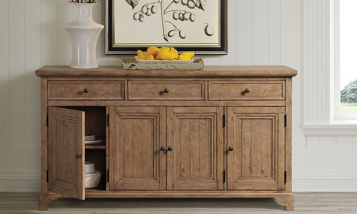 a large wooden cabinet with drawers underneath a painting