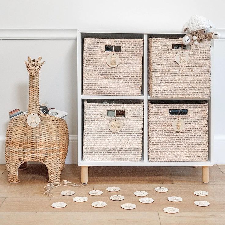 four wicker baskets sitting on top of a wooden floor next to a toy giraffe