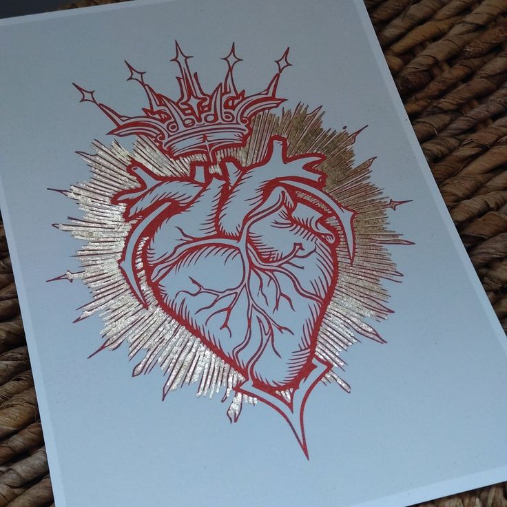 a card with a drawing of a heart and crown on the front, sitting on a wicker mat