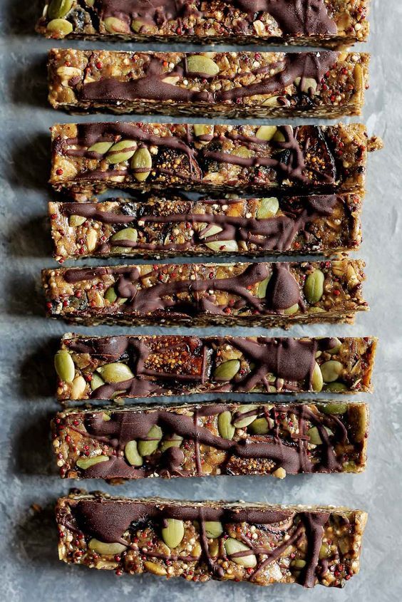 five pieces of granola bars with chocolate drizzled on top and sprinkled