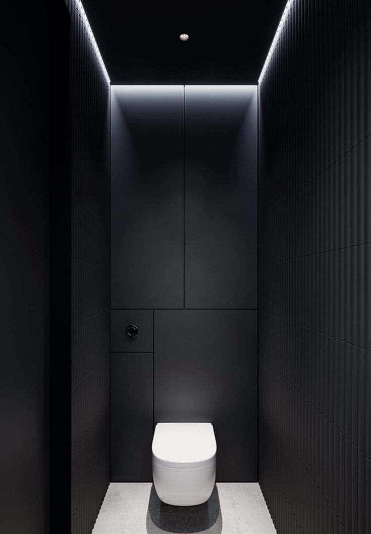 a white toilet sitting inside of a black bathroom