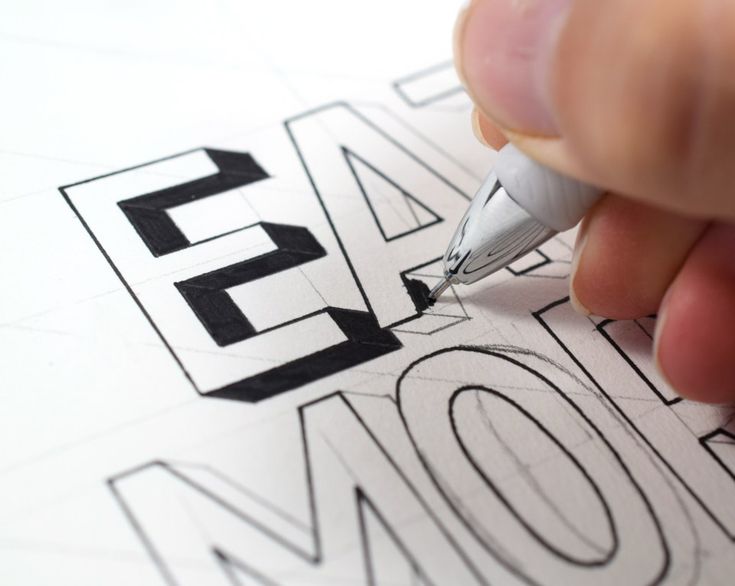 a person is drawing letters on paper with a pen and inking them into the word now