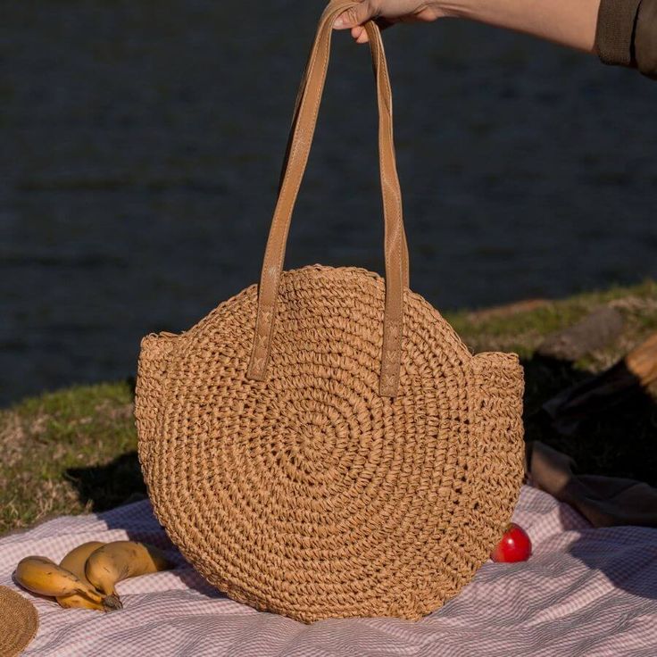 Introducing our Round Straw Bag - the epitome of summer chic and beach vibes. This rattan beach tote bag, also known as the Bali Bag, is the perfect accessory to elevate your style and bring a touch of bohemian charm to any outfit. Shape and Style: The bag's round shape adds a unique and trendy element to your look, making it a standout piece wherever you go. Its boho-inspired design is perfect for beach days, vacations, or casual outings, giving you that relaxed and carefree feel. Versatile Sho Chic Summer Bags Made Of Natural Fiber, Chic Beach Bag Made Of Natural Fiber, Everyday Summer Straw Shoulder Bag, Summer Everyday Straw Bags, Chic Summer Straw Bag For Everyday, Chic Everyday Summer Straw Bag, Summer Beach Bag With Braided Handles For Everyday, Spring Travel Beach Bag Made Of Rattan, Casual Summer Bags In Natural Fiber