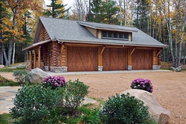 a large log home with two garages on each side