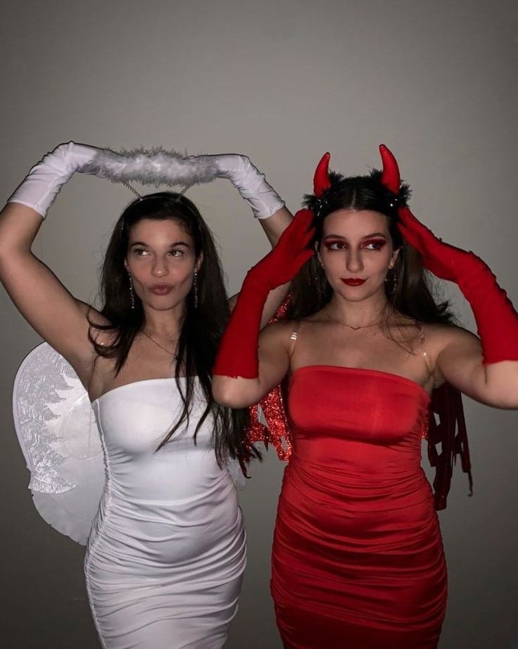 two women dressed in devil costumes posing for the camera