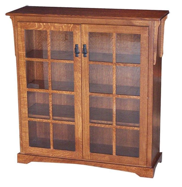 an oak bookcase with glass doors on the front and bottom shelves is shown against a white background