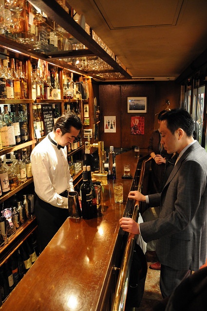 two men are standing at the bar