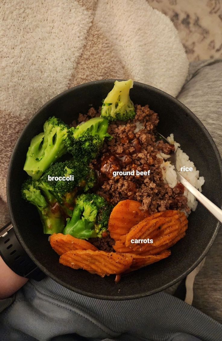 a bowl with broccoli, ground beef, carrots and rice in it