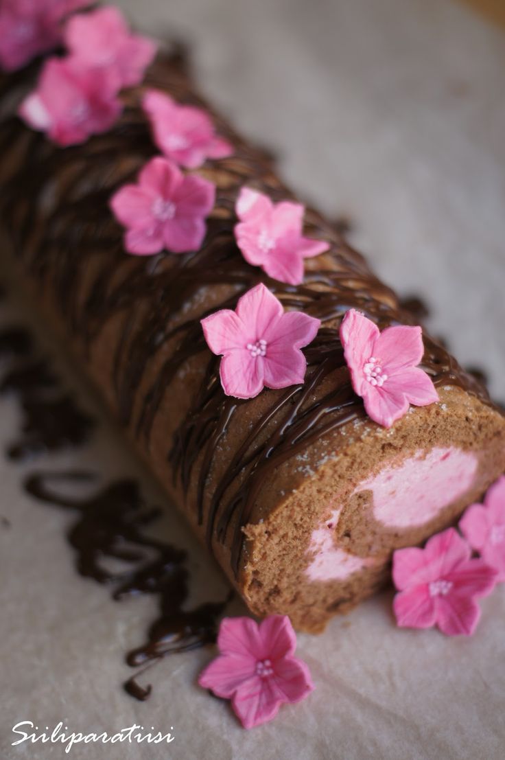 a chocolate roll with pink flowers on it