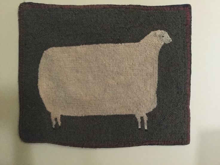 a sheep hooked up to the side of a wall hanging on a white wall in a room