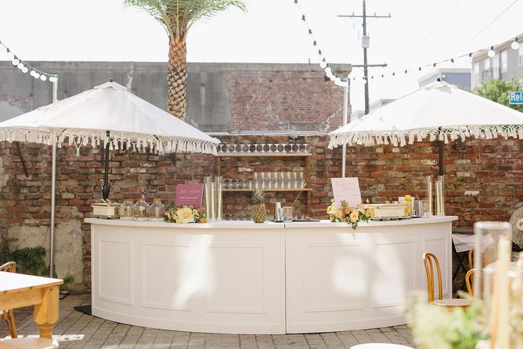 an outdoor bar with white umbrellas and tables