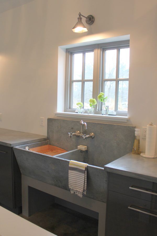 a kitchen sink sitting under a window next to a counter top with a towel hanging on it