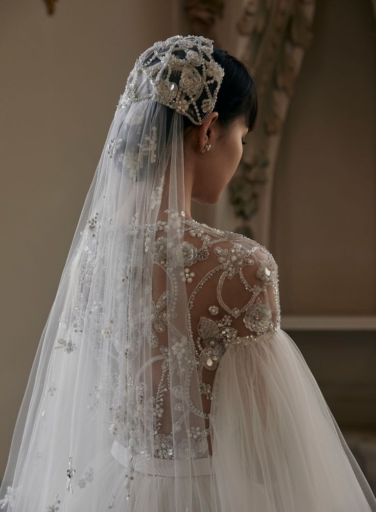 the back of a bride's wedding dress, with veil draped over her shoulder