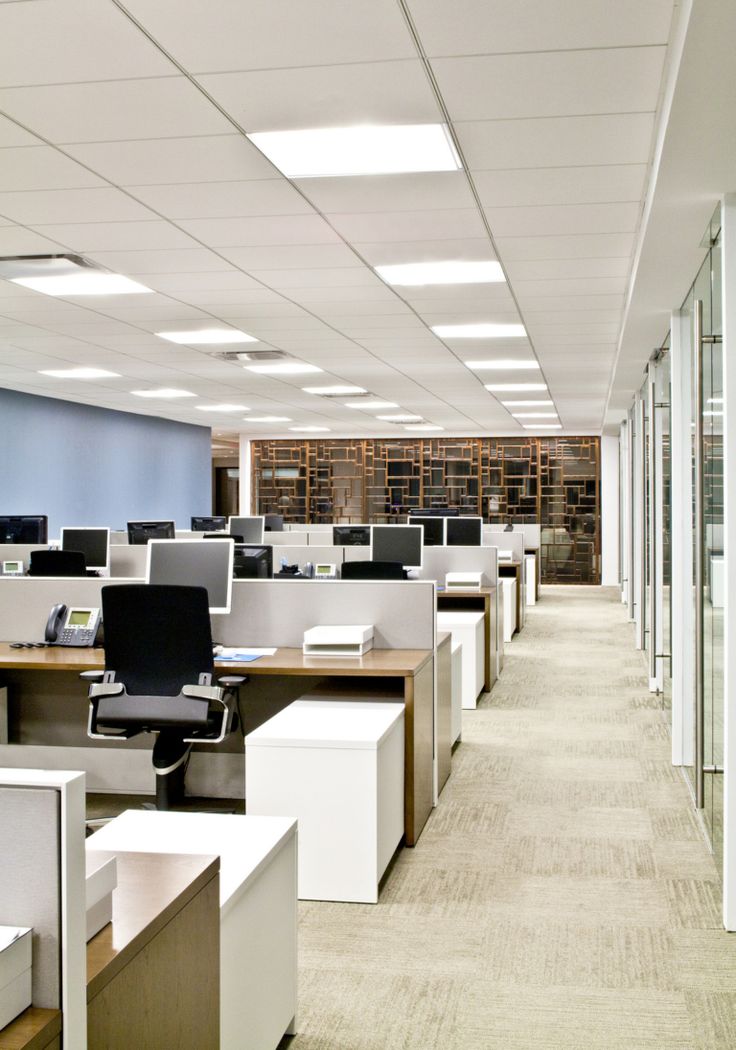 an empty office cubicle with desks and chairs