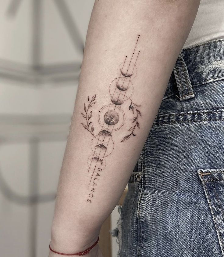 a woman's arm with a tattoo on it that has an arrow in the center