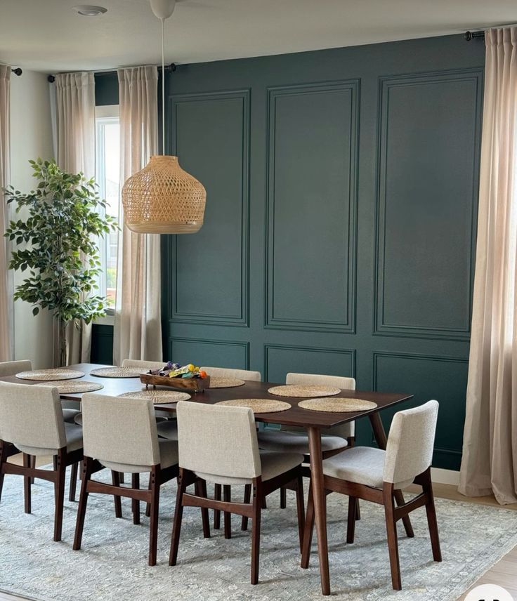 a dining room with green walls and chairs