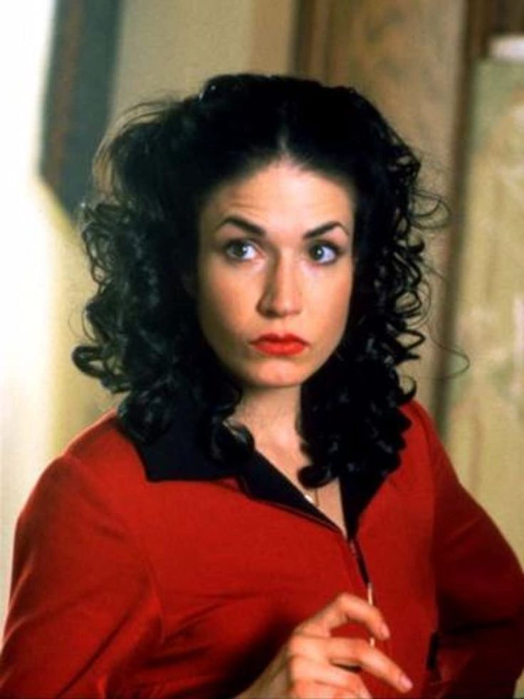 a woman with curly hair wearing a red shirt