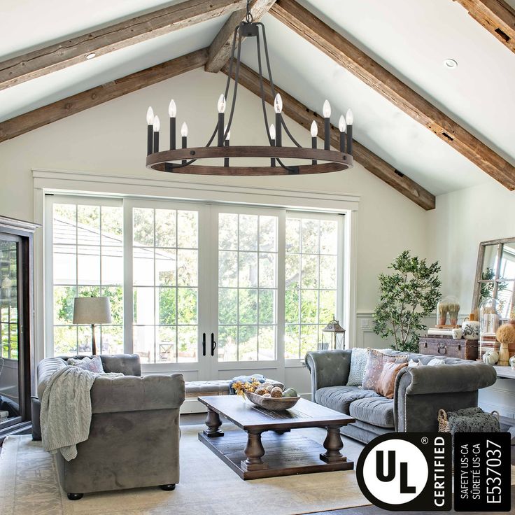 a living room filled with furniture and a chandelier hanging over the top of it