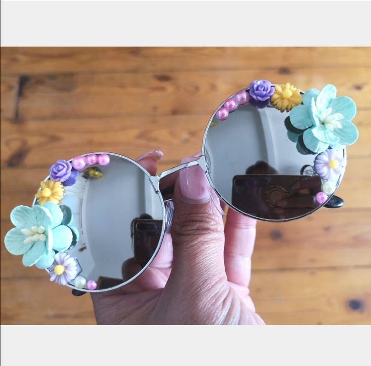 🌺Shade yourself from the sun in style with these pretty flower sunnies. 🌺These round sunnies have silver frames with silver mirrored lenses. On the sides of the glasses they have an array of pretty handmade flowers in shades of green, pink, purple and yellow with a few small flowers and pearls.  🌺Stand out  from the crowd in these sunglasses, perfect for holidays, Ibiza, festivals, carnivals etc. Dress them up for a special occasion or or down for everyday wear!  🌺 UV protection. 🌺All sunglasses are sent in a black pouch to keep them safe but please also handle with care as they are handmade. 🌺Check out the full collection of sunnies here:  https://etsy.me/2n7BAX8 ( Please note that colours may vary slightly depending on your screen / monitor) Fun Spring Festival Sunglasses, Silver Sunglasses With Mirrored Lenses For Spring, Silver Tinted Sunglasses For Spring, Silver Sunglasses With Uv Protection For Spring, Silver Sunglasses For Beach Spring, Silver Sunglasses For Beach And Spring, Silver Sunglasses For Beach And Spring Season, Silver Sunglasses For Beach Spring Season, Silver Sunglasses For Beach In Spring