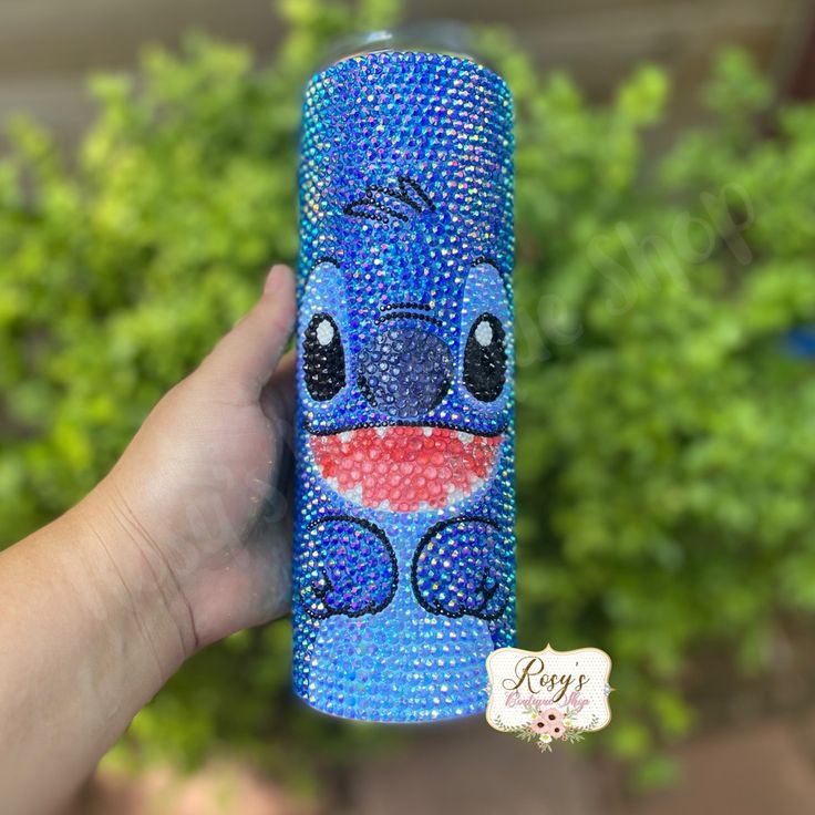 a hand holding a blue case with an image of stitching stitched onto it