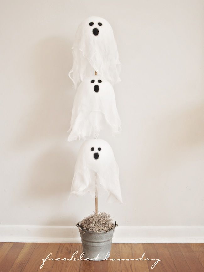 three ghost heads in a bucket on top of a wooden floor next to a wall