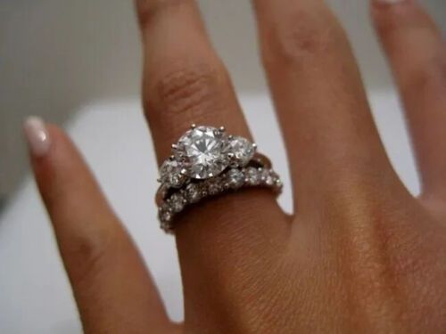 a woman's hand with two diamond rings on it