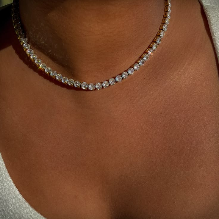 Introducing our 5mm Classic Diamond Tennis Necklace—a timeless blend of elegance and durability. Crafted from high-quality stainless steel, this necklace exudes sophistication while offering long-lasting wear. Adorned with bold 5mm shimmering zircon stones, adding a touch of sophistication to any ensemble. With its waterproof construction, you can wear it with confidence, whether you're hitting the town or lounging by the pool. Elevate your style effortlessly with this versatile accessory that s Tennis Chain Necklace Women, Rebecca Core, Girl Goals, Tennis Jewelry, Diamond Tennis Necklace, Classy Jewelry, Tennis Necklace, Stacked Jewelry, Anklet Bracelet