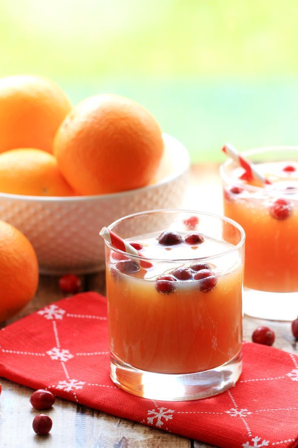 two glasses filled with orange juice and garnished with pomegranates