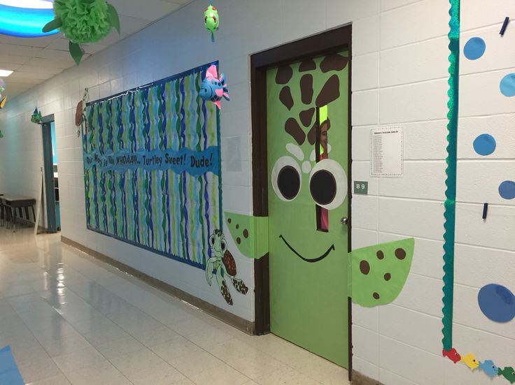 the hallway is decorated in green and blue with paper decorations on the wall, along with pictures of giraffes